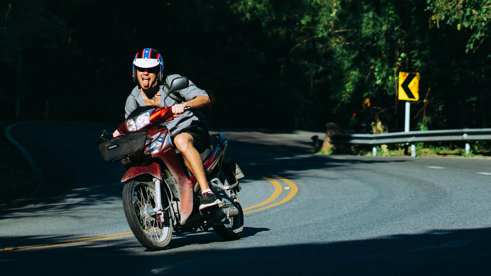 A man is riding a mopad on the road