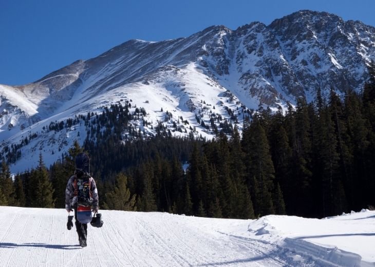 man holding ski gloves on snowy mountain ski resort