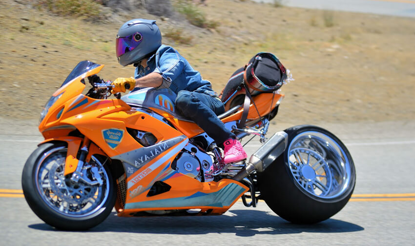 ride a motorcycle with fat tires on the road